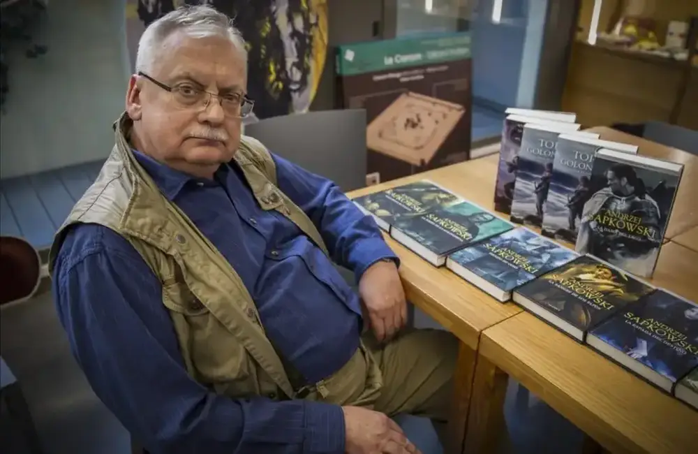 Autor da saga The Witcher ao lado de livros que, vendidos por pouco, geraram bilhões para outras empresas.